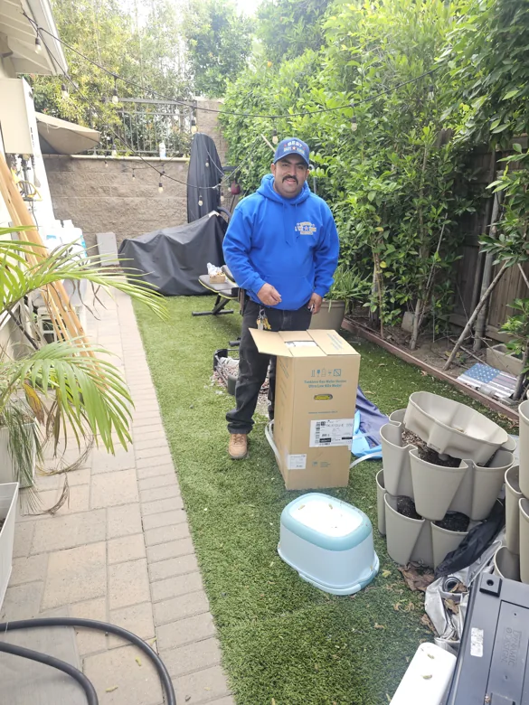 Technician beside removed toilet and boxed materials