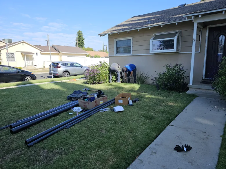 Long replacement pipes staged on front lawn