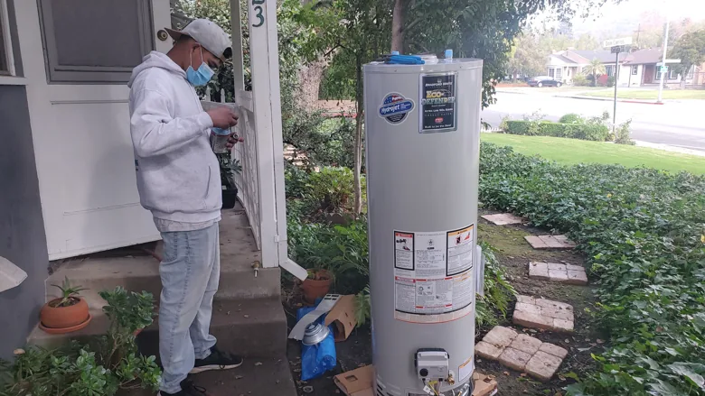 Technician beside new tank-style water heater