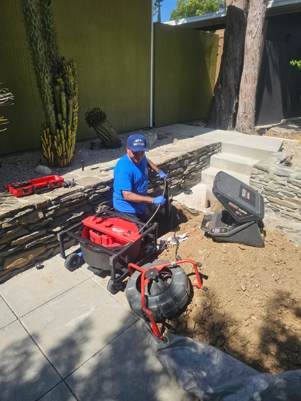 Technician with inspection monitor and cable reels outdoors