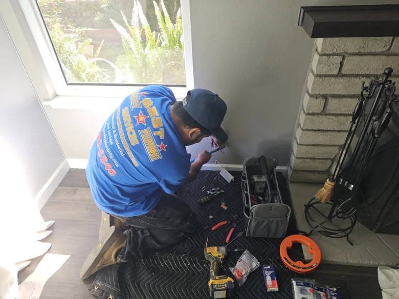 Technician with diagnostic equipment beside interior wall