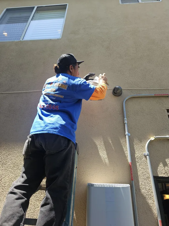 Technician working on exterior wall penetration