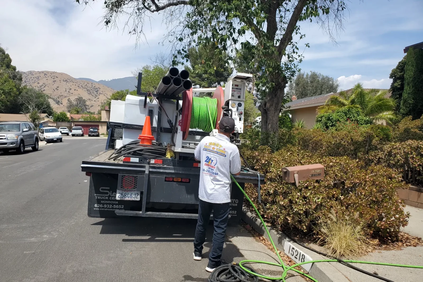 Technician operating truck-mounted hydro jetting hose equipment